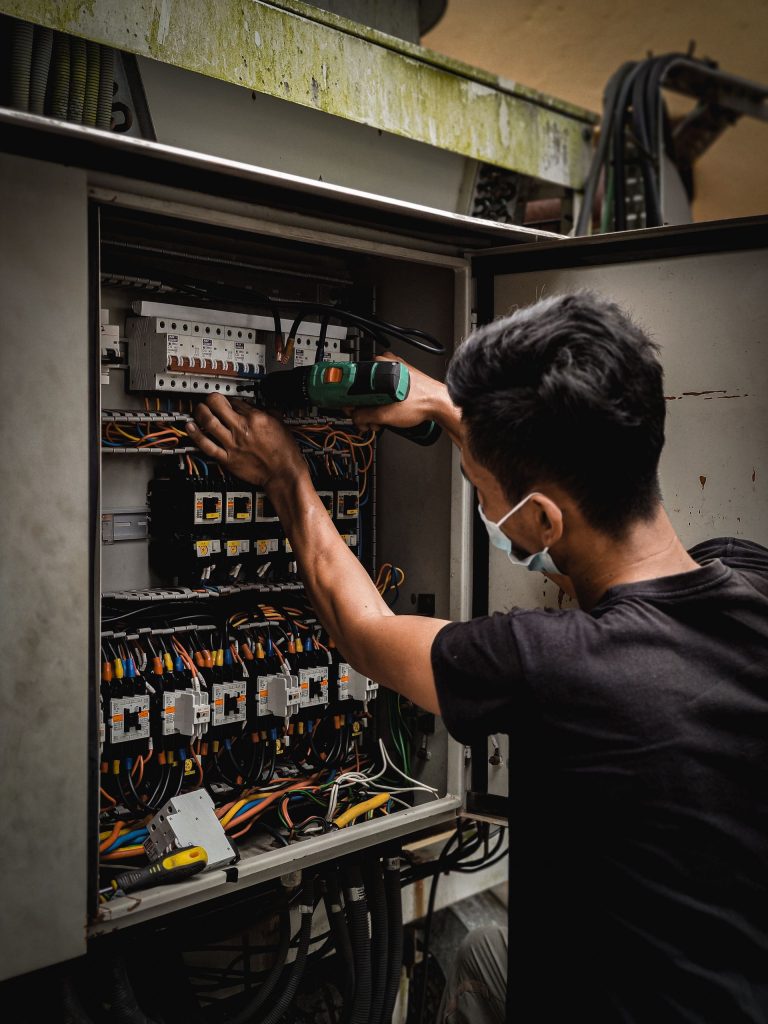 Electrician working inside an electrical control panel