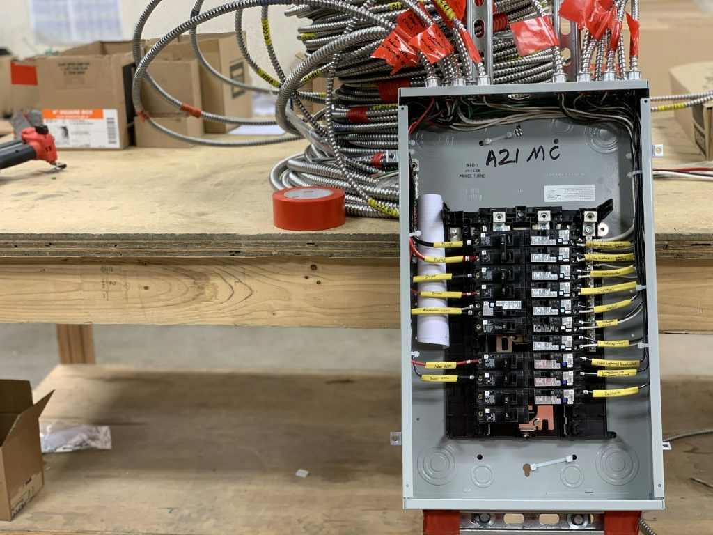 Residential load center wired and labelled circuit by circuit on a bench